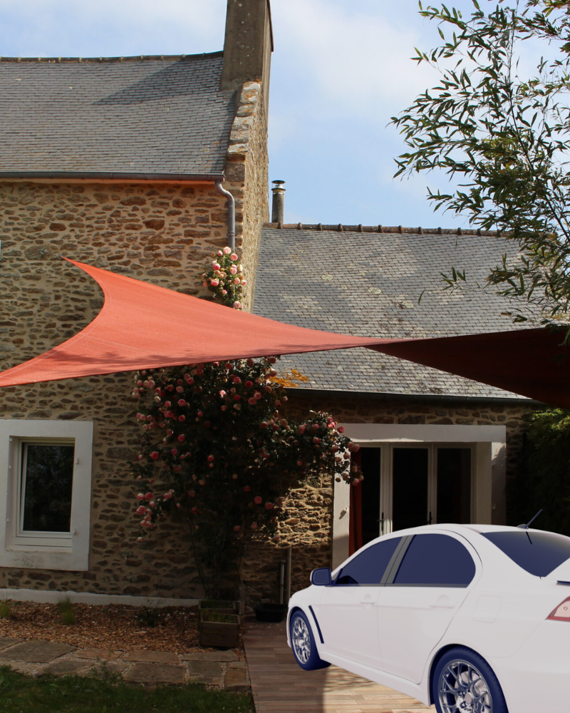 une voiture garée à l'ombre d'une voile d'ombrage